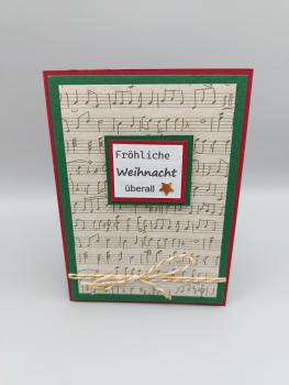 Handgemachte Weihnachtskarte mit Notenhintergrund und Stern – „Fröhliche Weihnacht überall“